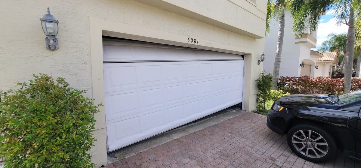 Off-track garage door exterior damage in Florida home