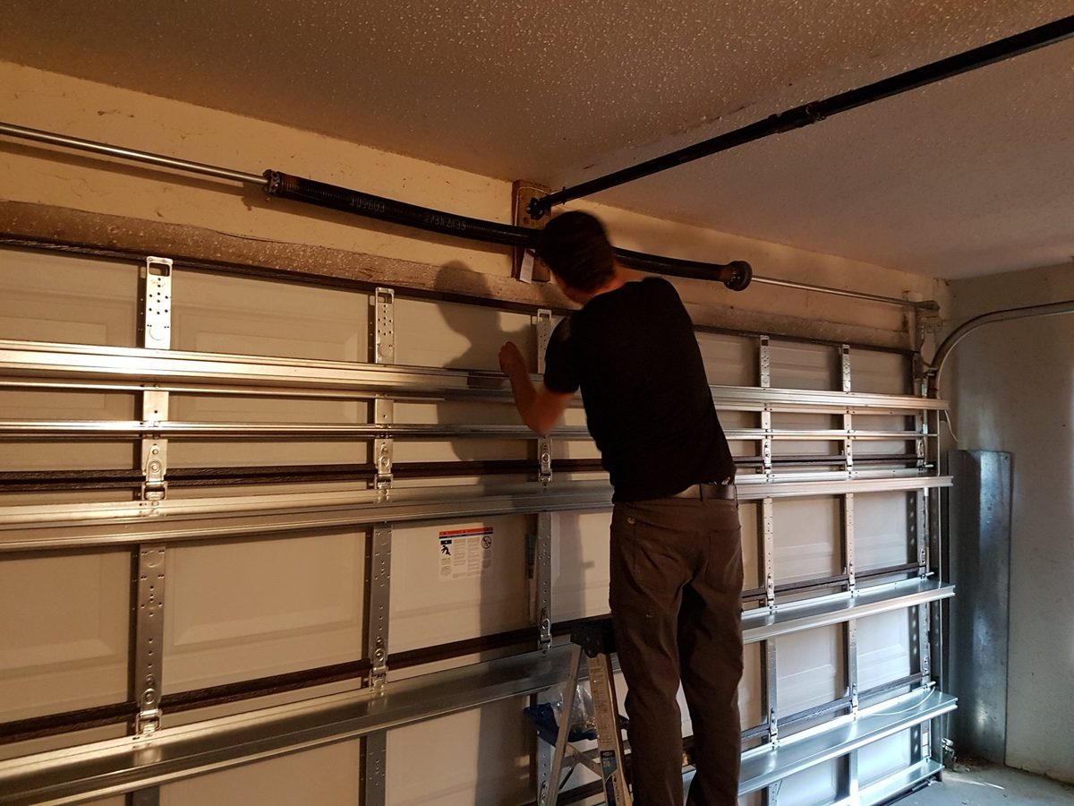 Technician replacing garage door torsion spring in Fort Lauderdale FL