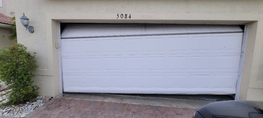 Damaged garage door panel before repair in South Florida